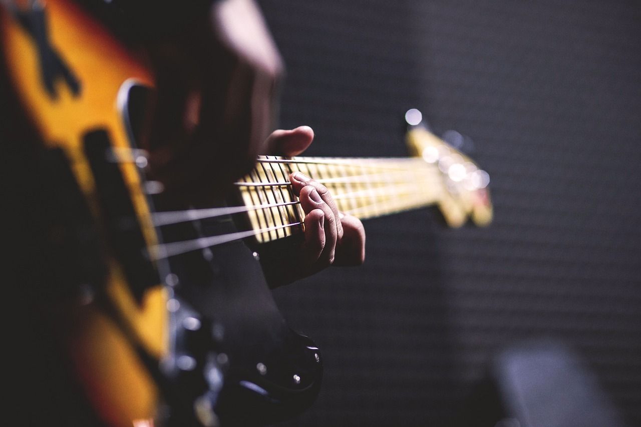 Mains jouant d’une guitare basse
